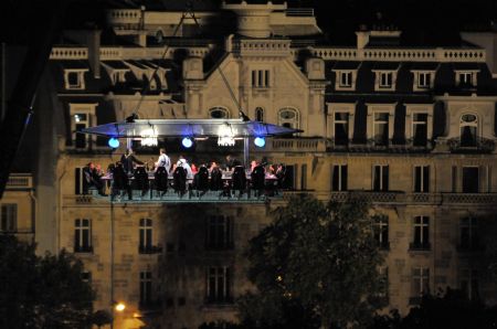 Guests have supper at a new event venue which offers 'Dinner in the Sky' as they are seated around a table that is lifted by a crane above the Tuileries Garden in Paris September 11, 2009.[Xinhua/AFP]