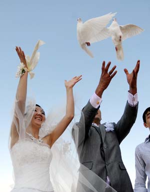 A newly-married couple sets free doves at the Victory Square in Bishkek, capital of Kyrgyzstan, Sept. 12, 2009. It is a tradition for many Kyrgyzstan's newly-married couples to come to the Victory Square to pray for happiness in their life.[Sadat/Xinhua]