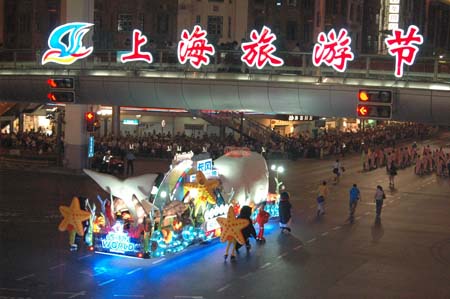 People watch a flowery float during the opening pageant of the 2009 Shanghai Tourism Festival on Huaihai road in Shanghai, east China, Sept. 12, 2009. Twenty-two flowery floats and 35 performing teams from at home and abroad took part in the pageant on Saturday.[Xinhua]