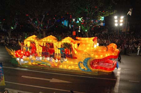 People watch a flowery float during the opening pageant of the 2009 Shanghai Tourism Festival on Huaihai road in Shanghai, east China, Sept. 12, 2009. Twenty-two flowery floats and 35 performing teams from at home and abroad took part in the pageant on Saturday. [Xinhua]