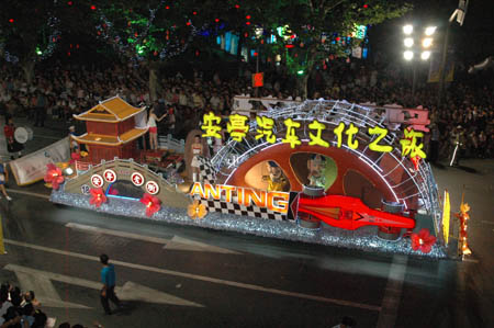 People watch a flowery float during the opening pageant of the 2009 Shanghai Tourism Festival on Huaihai road in Shanghai, east China, Sept. 12, 2009. Twenty-two flowery floats and 35 performing teams from at home and abroad took part in the pageant on Saturday. [Xinhua]