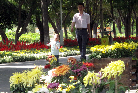A man with his son enjoys the flowers at an arboretum in Urumqi, northwest China's Xinjiang Uygur Autonomous Region, on Saturday, Sept. 12, 2009. (Xinhua/Shen Qiao)