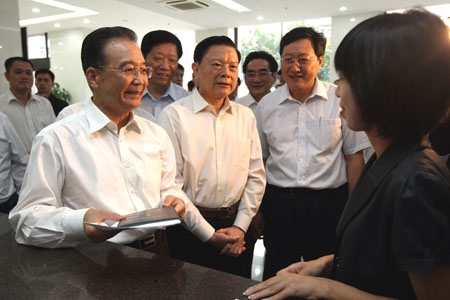 Chinese Premier Wen Jiabao (front, L) talks with a graduate at the employment and service center for college graduates in Dalian, northeast China's Liaoning Province, Sept.11, 2009.