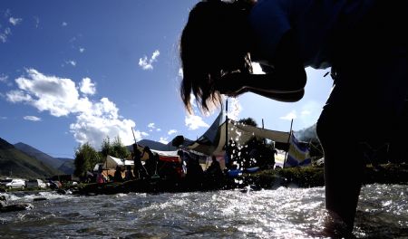 A woman of Tibetan ethnic takes a bath in a river in Lhasa, capital of southwest China's Tibet Autonomous Region Sept. 13, 2009, to celebrate the bath festival. The yearly bath festival is a special festival for people of Tibetan ethnic, which began Sept. 9 this year. (Xinhua/Purbu Zaxi) 