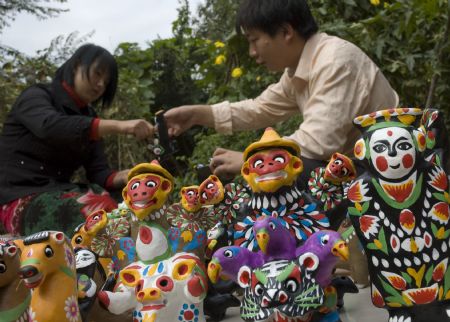 Folk craftsmen dry 'Nigugu', a traditional putty-made toy, at Yangjitun Village of Junxian County, central China's Henan Province, Sept. 12, 2009. The putty-made toy called 'Nigugu', literally meaning putty cluck, is a folk instrument which is played on the hole to produce different sounds such as cluck. (Xinhua/Chang Zhongzheng)