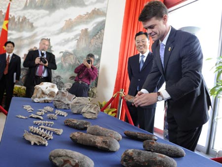 Chinese Embassy Deputy Chief of Mission Xie Feng (2nd R) watches as Assistant Secretary of Homeland Security for US Immigration, and Customs Enforcement John Morton handles a dinosaur egg during a repatriation ceremony for US Department of Homeland Security officials to turn over bones and eggs of pre-historic animals shipped illegally from China to the US, at the Chinese Embassy in Washington September 14, 2009.[