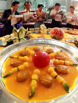 Judges mark dishes during a cooking competition greeting the 2010 Shanghai World Expo held in Wujiaochang in Yangpu District of Shanghai, east China, Sept. 15, 2009, which attracted chefs from 16 catering companies joining in the competition.[Xinhua]