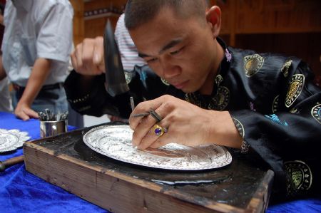 A competitor makes a silver ware during a traditional handicraft competition in Kaili, southwest China's Guizhou Province, Sept. 15, 2009.(Xinhua/Wu Ruxiong)