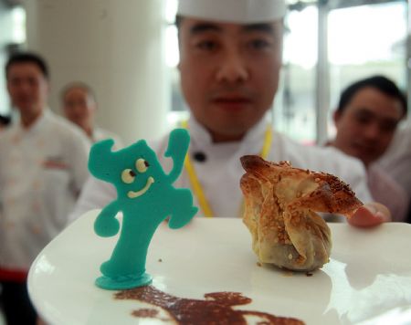 A chef shows a dish decorated with 'Haibao', mascot of the 2010 Shanghai World Expo, during a cooking competition greeting the 2010 Shanghai World Expo held in Wujiaochang in Yangpu District of Shanghai, east China, Sept. 15, 2009, which attracted chefs from 16 catering companies joining in the competition.(Xinhua Photo)