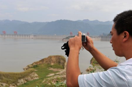 A tourist shoots photos of the Three Gorges reservoir in Yichang, a city of central China's Hubei Province, Sept. 15, 2009