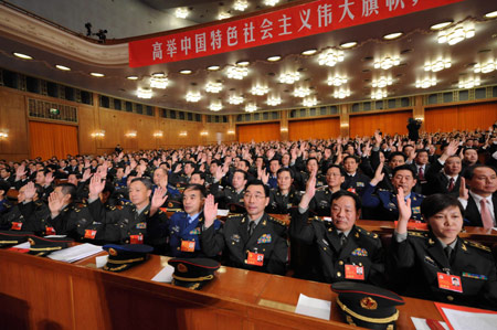 Delegates raise hands for a vote during the closing session of the 17th National Congress of the Communist Party of China (CPC) at the Great Hall of the People in Beijing, capital of China, Oct. 21, 2007. (Xinhua file photo)