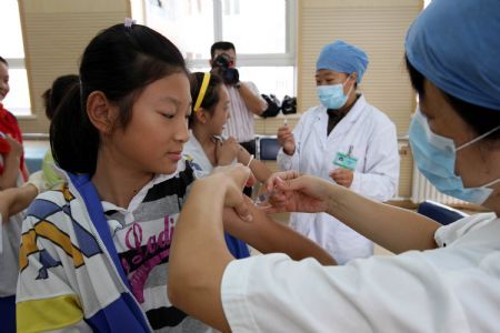 Pupils get flu vaccination shots at Hepingli No.9 Primary School in Dongcheng District of Beijing, capital of China, Sept. 16, 2009. Free vaccinations will be provided to 1.8 million residents in Beijing including senior people aged 60 or older as well as all primary and middle school students from Sept. 10 to Oct. 31 this year. (Xinhua/Zhou Liang)