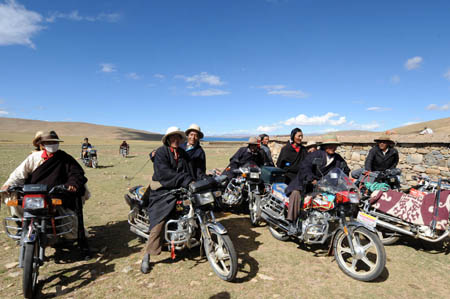Local herdsmen ride motorbikes to attend a house-warming party held by Cering Tonzhub for his new house in Bangoin County, southwest China's Tibet Autonomous Region, Sept. 15, 2009.(Xinhua