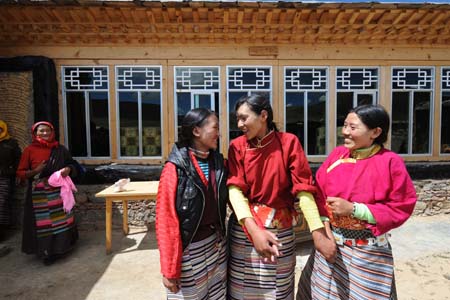 Tibetan girls smile in front of herdsman Cering Tonzhub's new house in Bangoin County, southwest China's Tibet Autonomous Region, Sept. 15, 2009.(Xinhua
