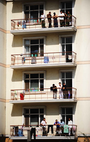 Students stand on the balconies of their dormitories at Heilongjiang University in Harbin, capital of northeast China's Heilongjiang Province, Sept. 16, 2009. Heilongjiang University scheduled to suspend class from 8:00 a.m. on Sept. 16 to Sept. 19 due to the A/H1N1 flu collective outbreak which was confirmed on Sept. 13.