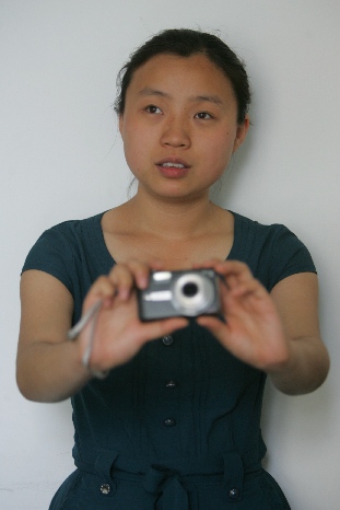 Jin Ling, an administrative assistant for One Plus One, takes a self-portrait. 一加一的行政助理金玲为自己拍摄照片。