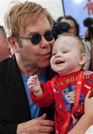 Pop singer Elton John kisses baby Lev during a news conference at a hospital for HIV-positive children in the town of Makeyevka outside Donetsk, September 12, 2009.