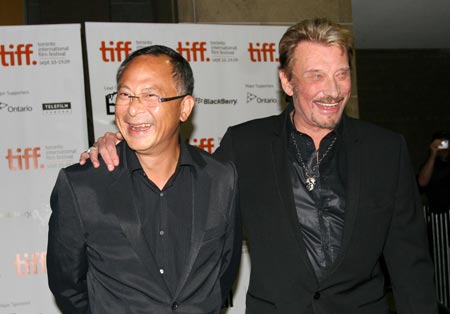 Hong Kong director Johnnie To (L) and French singer-actor Johnny Hallyday walk the red carpet before the screen of the film 'Vengeance' during the 34th Toronto International Film Festival, in Toronto, Canada, Sept. 15, 2009. 
