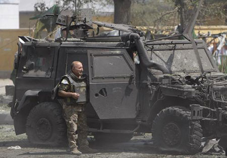 An Italian soldier stands in front of a burned truck after an explosion in Kabul September 17, 2009. A suicide car bomb hit an Italian military convoy on a road between the U.S. embassy and the main airport in the centre of Kabul on Thursday, killing at least six people and wounding dozens, Afghan and Italian officials said