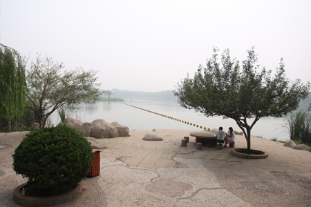 Two visitors rest in front of one of several lakes of South Lake Park in Tangshan city, in north China's Hebei province on August 15, 2009. The park, which was built over an old trash dump, was established by the Tangshan government in 2008. Tangshan, a coastal city near the Bohai sea, was totally rebuilt after a deadly earthquake destroyed it in 1976.[chinadaily.com.cn]