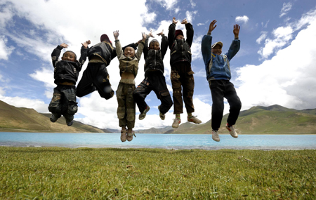 Tibetan children play on the shore of the Yamdrok Tso, one of the three largest sacred lakes in Tibet, August 16, 2009. [Xinhua]