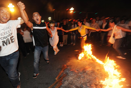 People dance around the bonfire during the torch festival in Xichang, capital of Liangshan Yi autonomous prefecture, Sichuan province, August 15, 2009. [Xinhua]