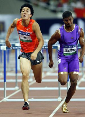 China's 110m-hurdler Liu Xiang (L) sprints towards the finishing line next to Terrence Trammell of the United States at the 2009 Shanghai Golden Grand Prix in Shanghai, China, on Sept. 20, 2009. Liu made a comeback on Sunday after his Olympic withdrawal, finishing second in 13.15 seconds. Trammell, who also clocked 13.15 seconds but beat Liu at photo finish, took the gold medal. (Xinhua/Fan Jun)