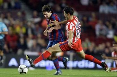 Barcelona's Leo Messi (L) is tackled by Atletico Madrid's Pablo Ibanez during their Spanish First Division soccer match at Camp Nou stadium in Barcelona September 19, 2009. (Xinhua/Reuters Photo) 