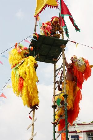 Performers stage the stunt show of dancing lions climbing onto ladder of daggers to mark the forthcoming grand celebration of the 60th anniversary of the founding of the People's Republic of China, at Hechi City, southwest China's Guangxi Zhuang Autonomous Region, Sept. 19, 2009.