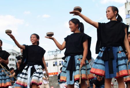 A group of young women take part in the teetotum gyration match to mark the forthcoming grand celebration of the 60th anniversary of the founding of the People's Republic of China, at Hechi City, southwest China's Guangxi Zhuang Autonomous Region, Sept. 19, 2009.(Xinhua/Zhou Enge)