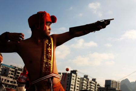 A younster shows his stunt of shooting crossbow to mark the forthcoming grand celebration of the 60th anniversary of the founding of the People's Republic of China, at Hechi City, southwest China's Guangxi Zhuang Autonomous Region, Sept. 19, 2009.(Xinhua/Zhou Enge)