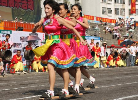 Contestants take part in the triplet bound plank shoes walking race to mark the forthcoming grand celebration of the 60th anniversary of the founding of the People's Republic of China, at Hechi City, southwest China's Guangxi Zhuang Autonomous Region, Sept. 19, 2009.(Xinhua/Zhou Enge)
