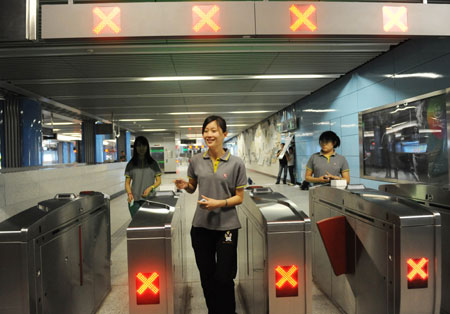 Workers try the ticket check-in sysytem at National Library station on Subway Line 4 in Beijng, capital of China, Sept. 21, 2009. Construction of the 28.2-kilometer-long Subway Line 4 entered the test phase recently. It will start trial operation before China's National Day on Oct. 1st. 