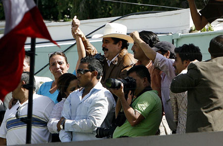 Ousted Honduran President, Manuel Zelaya (C), waves to supporters and reporters after arriving at the Brazilian Embassy in Tegucigalpa on Sept. 21, 2009. Manuel Zelaya, who was deposed from Honduras' presidency by a June 28 military coup, told media on Monday that he had returned to the nation's capital Tegucigalpa. (Xinhua)