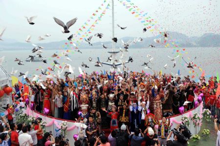 Newlyweds of 56 ethnic groups release pigeons to express their blessing for the motherland in Qiandaohu Scenic Area of Chun'an County, east China's Zhejiang Province, Sept. 20, 2009. A total of 56 pairs of newlywed couples of 56 ethnic groups gathered at Qiandaohu Scenic Area to join a group wedding on Sunday.(Xinhua/Zhou Jinyou)