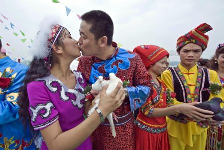 A pair of newlywed kiss each other at the wedding ceremony in Qiandaohu Scenic Area of Chun'an County, east China's Zhejiang Province, Sept. 20, 2009.(Xinhua/Li Suren)