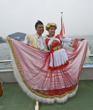 A pair of newlywed pose for photos at the wedding ceremony in Qiandaohu Scenic Area of Chun'an County, east China's Zhejiang Province, Sept. 20, 2009.(Xinhua/Zhou Jinyou)