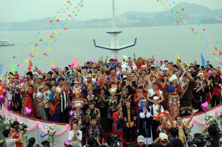 Newlyweds of 56 ethnic groups pose for a group photo at the wedding ceremony in Qiandaohu Scenic Area of Chun'an County, east China's Zhejiang Province, Sept. 20, 2009.(Xinhua/Zhou Jinyou)