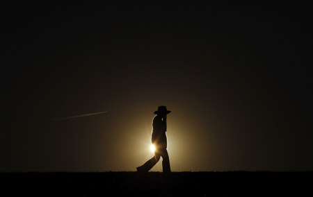 A pedestrian walks around Chestnut Hill Reservoir, as the sun sets on the final full day of summer, in Boston, Massachusetts September 21, 2009.(Xinhua/Reuters Photo)