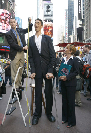 The world's tallest man, Sultan Kosen of Turkey, is measured by an official from Guinness World Records in New York's Times Square, September 21, 2009. The 26-year-old is 2 metres 46.5 cm (8 feet 1 inch) tall, also claiming the record for the largest hands and feet. Kosen is in New York to promote the Guinness book of World Records 2010.(Xinhua/Reuter Photo)
