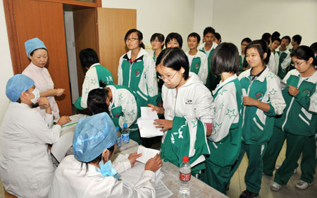 Students from the High School affiliated to Minzu University of China prepare to receive the A/H1N1 flu vaccinations in Beijing, capital of China, on Sept. 21, 2009. The national capital Beijing took the lead in the country to start A/H1N1 flu vaccination program Monday, the municipal health authorities announced. 