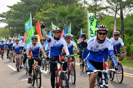 Locals ride bicycles during a public awareness event to mark the Car-Free Day in Haikou, capital of south China's Hainan Province, on Sept. 22, 2009. This Tuesday is China's third Car-Free Day and people are encouraged to walk, ride bikes or take buses instead of driving their cars. [Guo Cheng/Xinhua]