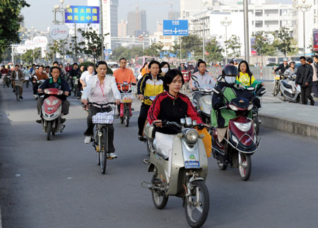 Locals ride bicycles and motorcycles on a street in Lianyungang, east China's Jiangsu Province, Sept. 22, 2009. This Tuesday is China's third Car-Free Day and people are encouraged to walk, ride bikes or take buses instead of driving their cars. [Gen Yuhe/Xinhua]