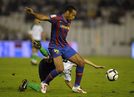 Barcelona's Thierry Henry (top) battles for the ball with Racing Santander's Manuel Arana during their Spanish First Division soccer match at Santander's El Sardinero stadium September 22, 2009.