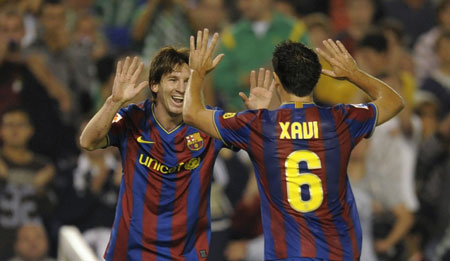 Barcelona's Lionel Messi (L) celebrates his goal against Racing Santander with his team mate Xavi Hernandez during their Spanish First Division soccer match at Santander's El Sardinero stadium September 22, 2009.