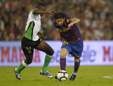 Barcelona's Lionel Messi (R) battles for the ball with Racing Santander's Papakouli Diop during their Spanish First Division soccer match at Santander's El Sardinero stadium September 22, 2009.