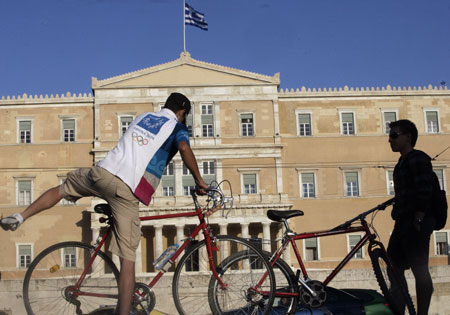Two young men ride bicycles as an act to response to the World Car Free Day in Athens, capital of Greece, Sept. 22, 2009. (Xinhua/Marios Lolos)