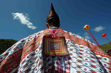 A woman of the Miao ethnic group shows up her cloak during the opening ceremony of a leek flower cultural festival held in Hezhang, southwest China's Guizhou Province, Sept. 22, 2009. The festival opened on Tuesday in Hezhang county that grows wild leek plants of more than 30 square kilometers.(Xinhua)