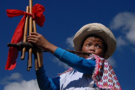 A kid of the Miao ethnic group performs during the opening ceremony of a leek flower cultural festival held in Hezhang, southwest China's Guizhou Province, Sept. 22, 2009. The festival opened on Tuesday in Hezhang county that grows wild leek plants of more than 30 square kilometers.(Xinhua)