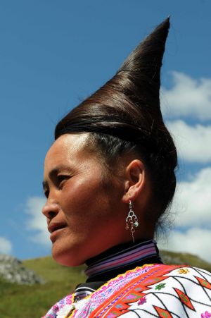 A full-dressed woman of the Miao ethnic group attends the opening ceremony of a leek flower cultural festival held in Hezhang, southwest China's Guizhou Province, Sept. 22, 2009. The festival opened on Tuesday in Hezhang county that grows wild leek plants of more than 30 square kilometers.(Xinhua)